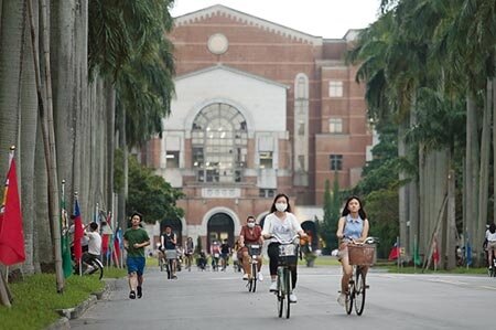 英國高等教育調查公司QS10日公布「2021世界大學排行」，台灣大學名列66，是台灣唯一列全球前百大的學府，比去年的69名再進步，創下台大歷年來最好的排名，學生悠閒騎著腳踏車行經椰林大道。(陳怡誠攝) 