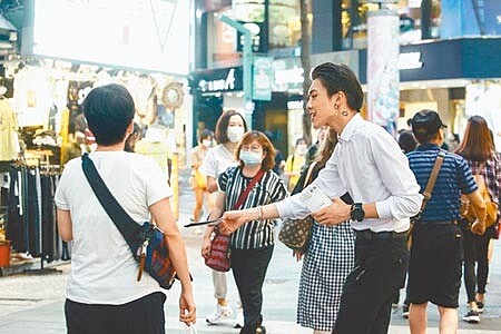 勞動部每季會召開基本工資工作小組會議,但今年受疫情影響,第1季取消,隨疫情趨緩,勞動部11日表示,預計6月底召開工作小組會議,也可能討論審議委員會召開時間。圖為西門町傍晚,一位上班族在街上發傳單給消費者。(鄧博仁攝)