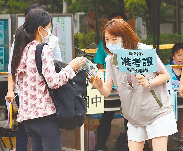 大學指考7月3日至5日舉行,考生進入考區時要出示識別證與量體溫,應試時全面配戴口罩,圖為國中會考考生依要求出示准考證,量體溫後進入考場。(中時電子報資料照片)