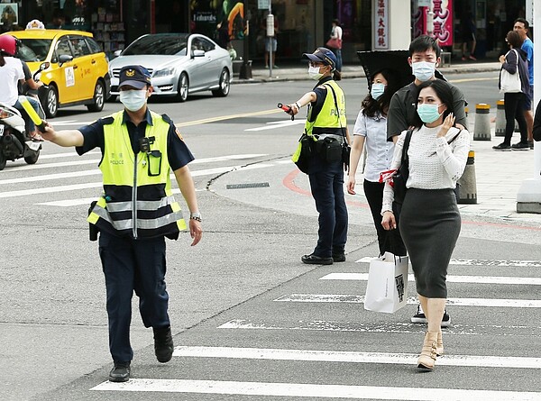 交通大執法加強取締車輛不禮讓行人，不過議員質疑有行人過馬路慢吞吞，導致塞車，圖為警方保護行人執法狀況。 圖／聯合報系資料照片