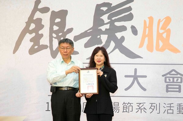 臺北市長柯文哲(左)頒發謝狀，感謝永慶慈善基金會對長者的關懷。永慶慈善基金會副執行長林麗華(右)代表接受。