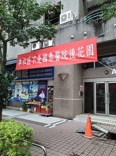 汐止國泰醫院對街的社區長期遭到癮君子影響居住環境及品質,住戶特別貼出紅布條希望能達到嚇阻效果。圖/截自臉書社團《汐止集團》