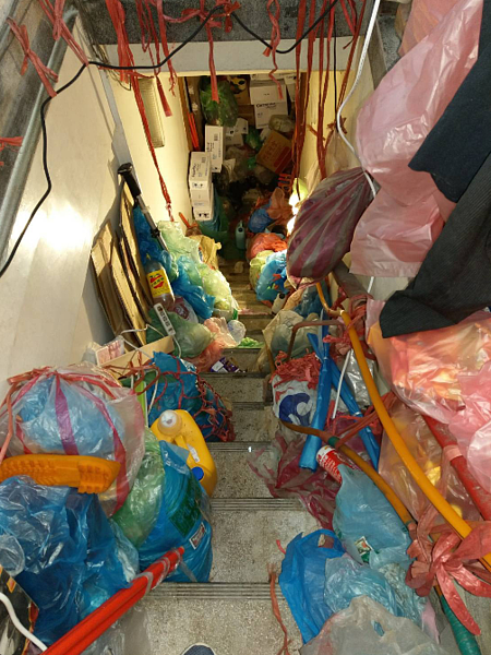 台北市信義區一處公寓,因屋主愛囤物,屋內堆滿雜物長期未清理,鄰居常聞惡臭,困擾不已。圖/北市議員戴錫欽辦公室提供