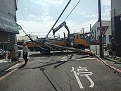 扯！吊車疑忘收吊臂　勾斷兩支電桿橫躺馬路釀摔車