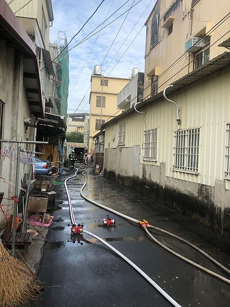 台中市霧峰區五福路窄巷內一棟三樓民宅在今天下午2時11分傳火警,且延燒到隔壁建築物,消防水車進不來,消防員以拉水線方式灌救。圖/台中市消防局提供