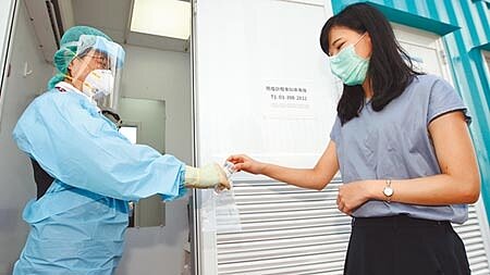 昨天是台灣新冠肺炎疫情持續本土零個案第200天，不過疫情指揮中心持續公布國內新增3例境外移入個案，圖為桃園機場採檢站內，1名旅客正在採集唾液檢體。（本報資料照片） 