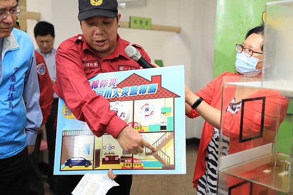 義消吳明政說明火災警報器在偵測到煙霧時,能夠發揮警示功能。圖/市公所提供