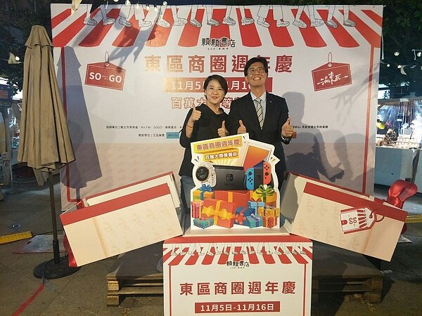 台北市副市長黃珊珊(左)與台北市東區商圈發展協會常務理事楊政憲(右)揭開東區商圈週年慶抽獎活動獎項。圖/台北市商業處提供