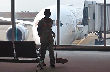 勞動部日前發布函釋指出,疫情為「事變」之一,使事業單位可以不用依照勞基法每天、每月加班上限、7休1等規定。圖為清潔人員正在打掃空蕩蕩的桃園機場候機室。(范揚光攝)