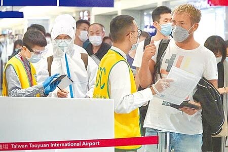 上海市衛健委24日公告新增5例境外輸入的新冠肺炎病例,其中1例為台灣籍。圖為桃機入境旅客依規定接受檢疫官審查入境資料。(本報資料照片)
