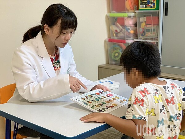 小男孩由語言治療師帶領透過圖卡、故事書、口腔運動遊戲，進行嘴唇、舌頭、臉頰肌肉的訓練正確發音。圖／澄清醫院中港院區提供