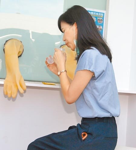 為減少醫護負擔及受檢者不適，中央流行疫情指揮中心宣布1日起，機場新冠肺炎採檢改採深喉唾液檢體，在桃園機場的採檢站內，1名旅客正在採集唾液檢體。（范揚光攝）