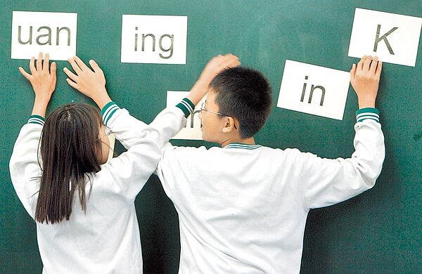 教育部長潘文忠堅持,111學年起將本土語文納入國高中必修課程。圖為老師以閩南語發音讓小朋友立即以羅馬符號拼出。(本報資料照片)