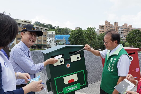 新北市副市長陳純敬（左二）視察青潭國小周邊計畫道路開闢工程，將「北宜路二段82巷通車紀念明信片」投入郵筒，象徵道路正式啟用。圖／新北市工務局提供