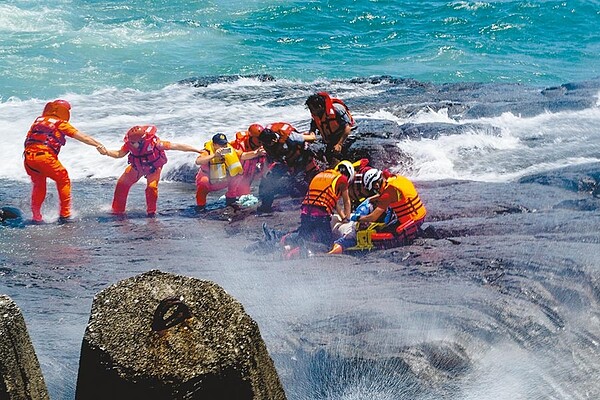 宜蘭縣頭城鎮大溪漁港10名釣客因瘋狗浪而落海，陸海空等單位聯手救援，岸巡人員在風浪下冒險救人。（李忠一攝）