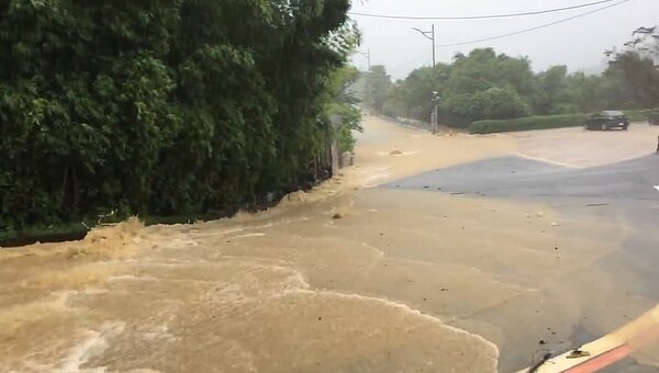 民眾目擊基金路一段上淹水，造成土石流水不斷猛灌覆蓋原先柏油道路。圖／截自臉書社團《基隆人》