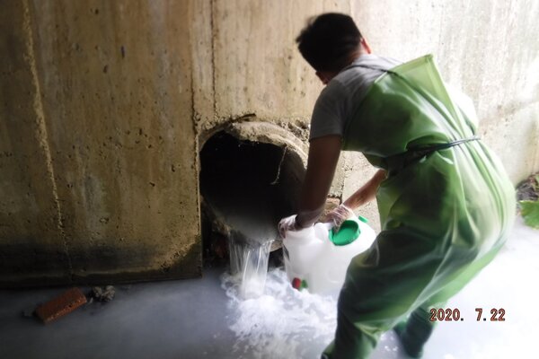 稽查員於廠外涵洞查獲排放超標鹼性廢水。圖／新北市環保局提供