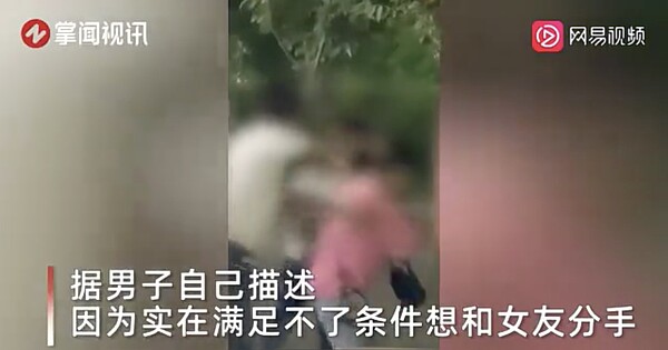 白衣男子激動到直接賞女友2個耳光，路邊一位大媽見狀連忙過去勸架，把男子一把推開。 圖截自《網易直播》