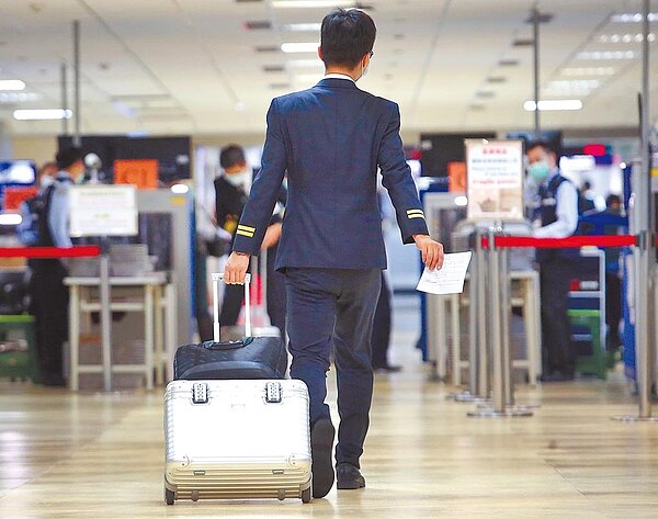 長榮航空對機組員下達耶誕、跨年活動的禁趴令。圖為1名長榮航空機組員結束飛行任務後,在桃園機場準備入境。(范揚光攝)