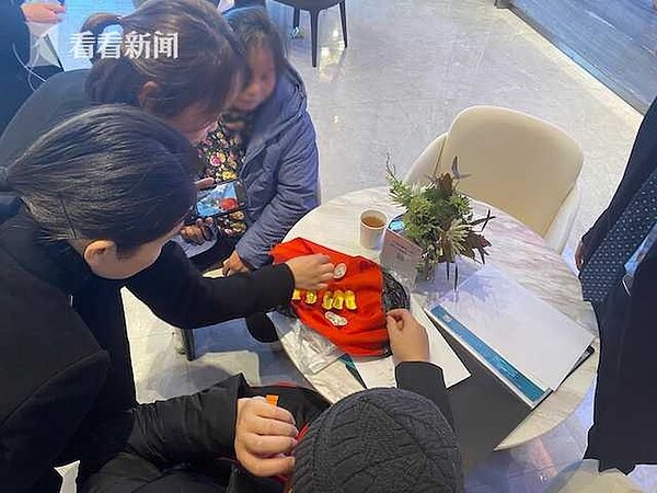 一名婦人掏出「真金白銀」支付房款,讓售樓處的工作人員們當場傻眼。圖/取自看看新聞