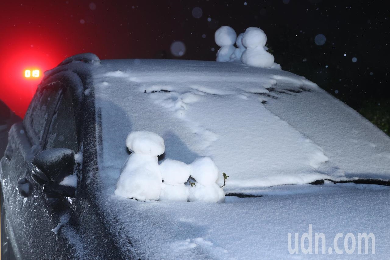 陽明山凌晨下雪，吸引數百民眾賞雪堆雪人，有民眾在車頂堆滿雪人，分享看到雪的喜悅。記者蘇健忠／攝影