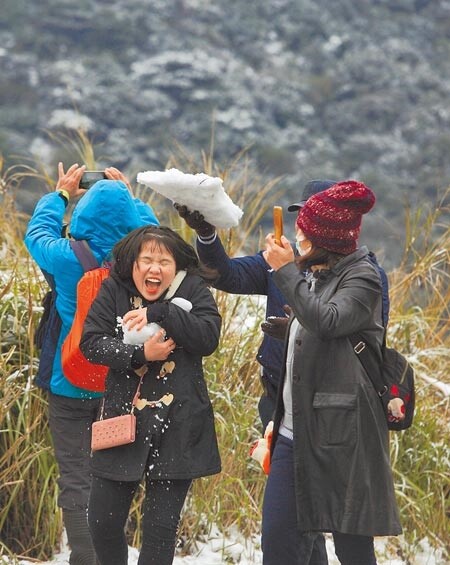 全台急凍，大屯山持續飄下細雪，許多民眾紛紛穿上冬衣衝上山賞雪，並在登山步道與朋友打雪仗。圖／張鎧乙攝