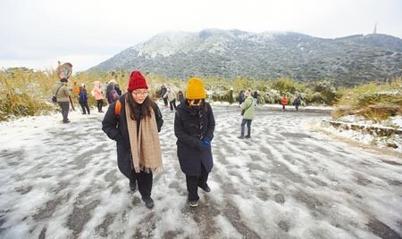 全台急凍，大屯山持續飄下細雪，許多民眾紛紛穿上冬衣衝上山賞雪，並在登山步道與朋友打雪仗。圖／張鎧乙攝