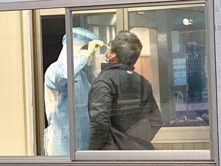 桃園某醫院爆發4名醫護確診，17日不斷有人前往醫院急診室外戶外採檢室接受採驗。（蔡依珍攝）
