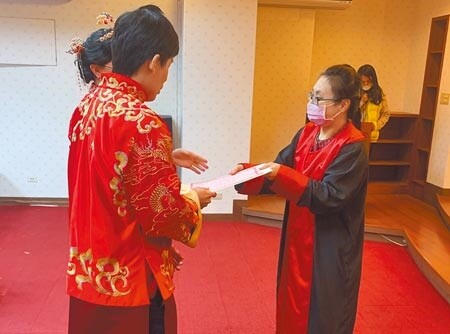 結婚新人精心打扮到法院結婚禮堂，公證人提醒拿到證書後要記得到戶政機關完成登記。（李文正攝）