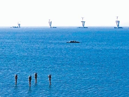 可望於年底完工的金門大橋,與浯江溪畔的裝置藝術「牡蠣人」遙遙相對。(李金生攝) Facebook