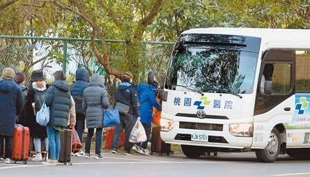 部立桃園醫院院內群聚感染擴大,指揮官陳時中昨宣布執行醫院清空計畫。圖為醫院人員登上專車準備居家隔離。(范揚光攝)
