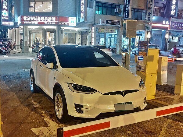 白色特斯拉停在停車場入口處的柵欄前一動也不動,裡面也沒有人,影響人車進出。圖/取自臉書爆料公社