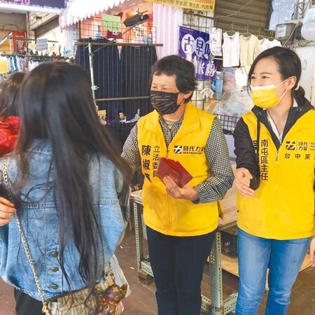 時代力量黨主席陳椒華(中)24日偕同台中黨部同仁一起到北屯市場發紅包,並向攤商和買菜市民提早賀年。(馮惠宜攝)