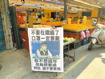 有大湳市場水果攤自製看板，以指揮官陳時中照片寫上「你不想過年，但我想過」，呼籲大家戴好口罩。（蔡依珍攝）