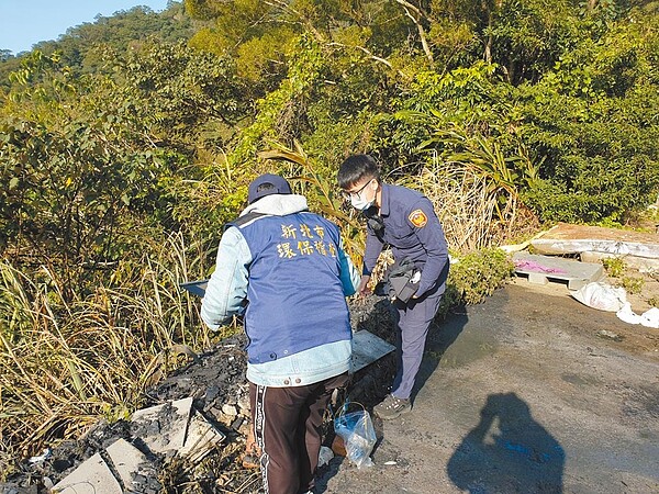 環保稽查員偕同警方至現場勘查,發現林男未妥善處理餘燼,反而將其推下山坡,以致悶燒冒煙。(新北市環保局提供/葉德正新北傳真)
