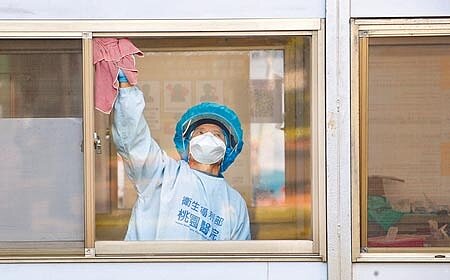 中央流行疫情指揮中心30日公布,國內新增4例本土新冠確診病例。在桃園醫院戶外診療區內,清潔人員正忙著消毒環境。(范揚光攝)