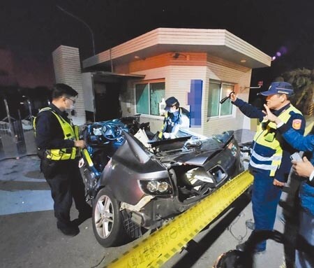 台南市安南區台江大道重大車禍，員警檢視自撞工廠警衛室的馬3自小客車。（洪榮志攝）