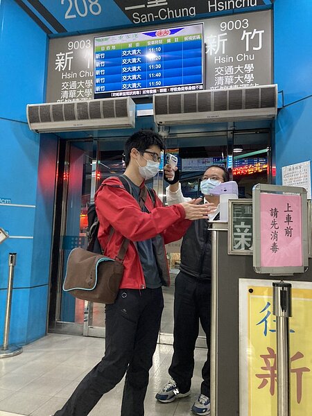 服務人員為乘客量測額溫及進行手部消毒。圖/三重客運提供