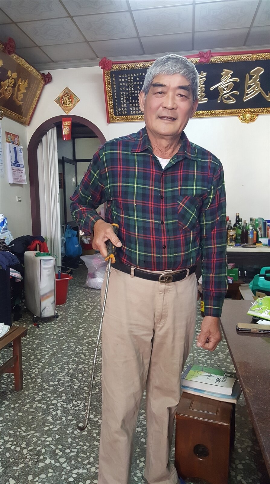 苗栗縣造橋鄉大西村長黃德仁,用鐵鉤子幫老婦找回被當垃圾丟掉的5萬多元現鈔。記者胡蓬生/攝影