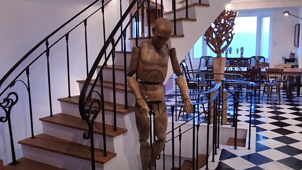 玄關有個人形木偶古董,柯震東拿來當作掛帽子、外套的衣架。圖/截自柯震東youtube頻道