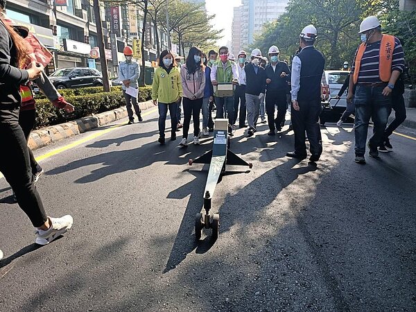 高雄鳳山文衡路鋪面改善完工後,副市長林欽榮、立委許智傑等人一同以平坦儀檢測路平。圖/高雄市政府提供