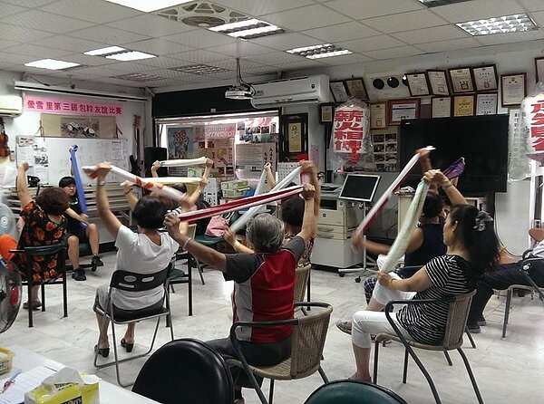 螢雪里辦公處聯手中正健康服務中心、聯合醫院和失智症協會等,定期舉辦健康成長講座和體適能課程。圖為復健科醫師帶領里民跳毛巾操。圖/擷取自台北市螢雪里臉書