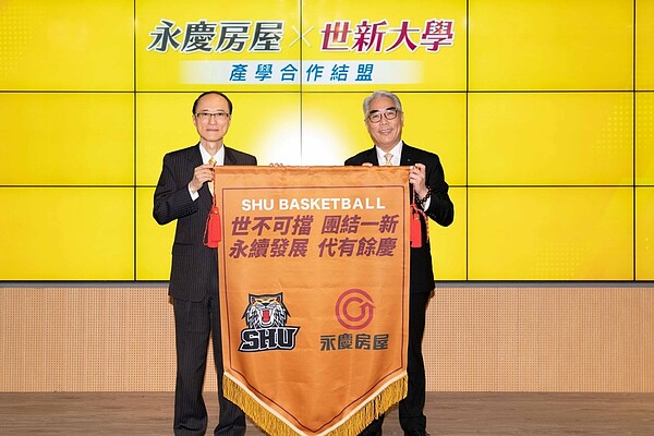 世新大學副校長楊盛昱致贈錦旗給永慶房屋董事長孫慶餘,期待未來的產學合作計畫展開。