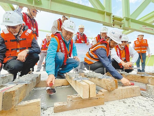 林佳龍(前右)與楊鎮浯(中)參與溼接縫抹平工程,象徵金門大橋從此邁向新的里程。(縣府提供/李金生金門傳真)