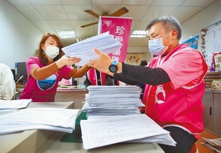 針對藻礁公投連署盛況不斷升高,在環團藻礁公投總部內,身穿粉色上衣的志工正忙著清點連署書。(范揚光攝)