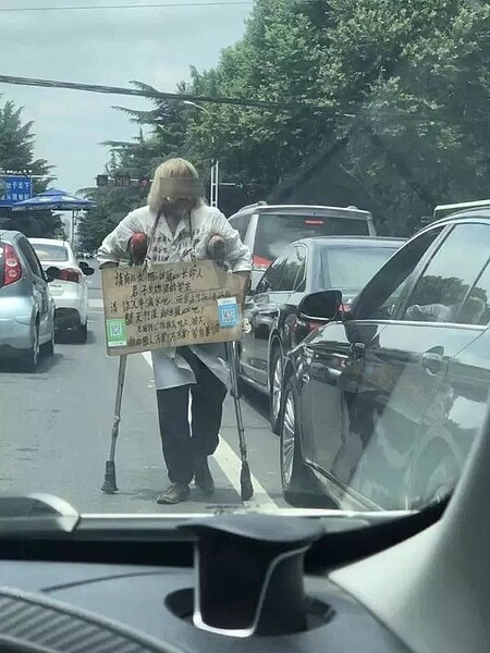 河南老人假扮乞丐，背著掃碼牌在街上向駕駛討錢，有網友拍下他上銀行存錢的畫面，曝光他是銀行VIP。圖／取自上游新聞