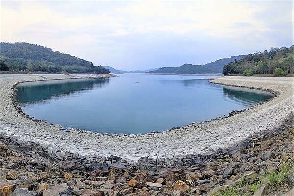 日月潭月牙灣因水位持續下探,岸邊礫石裸露範圍更大,且因露出水面時間不同而呈現不同顏色,猶如「年輪蛋糕」,成為另類奇觀。圖/讀者提供
