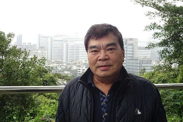 詹坤隆里長於中南里沿山步道,背後是今日的南港軟體經貿園區。張沛齊∕攝