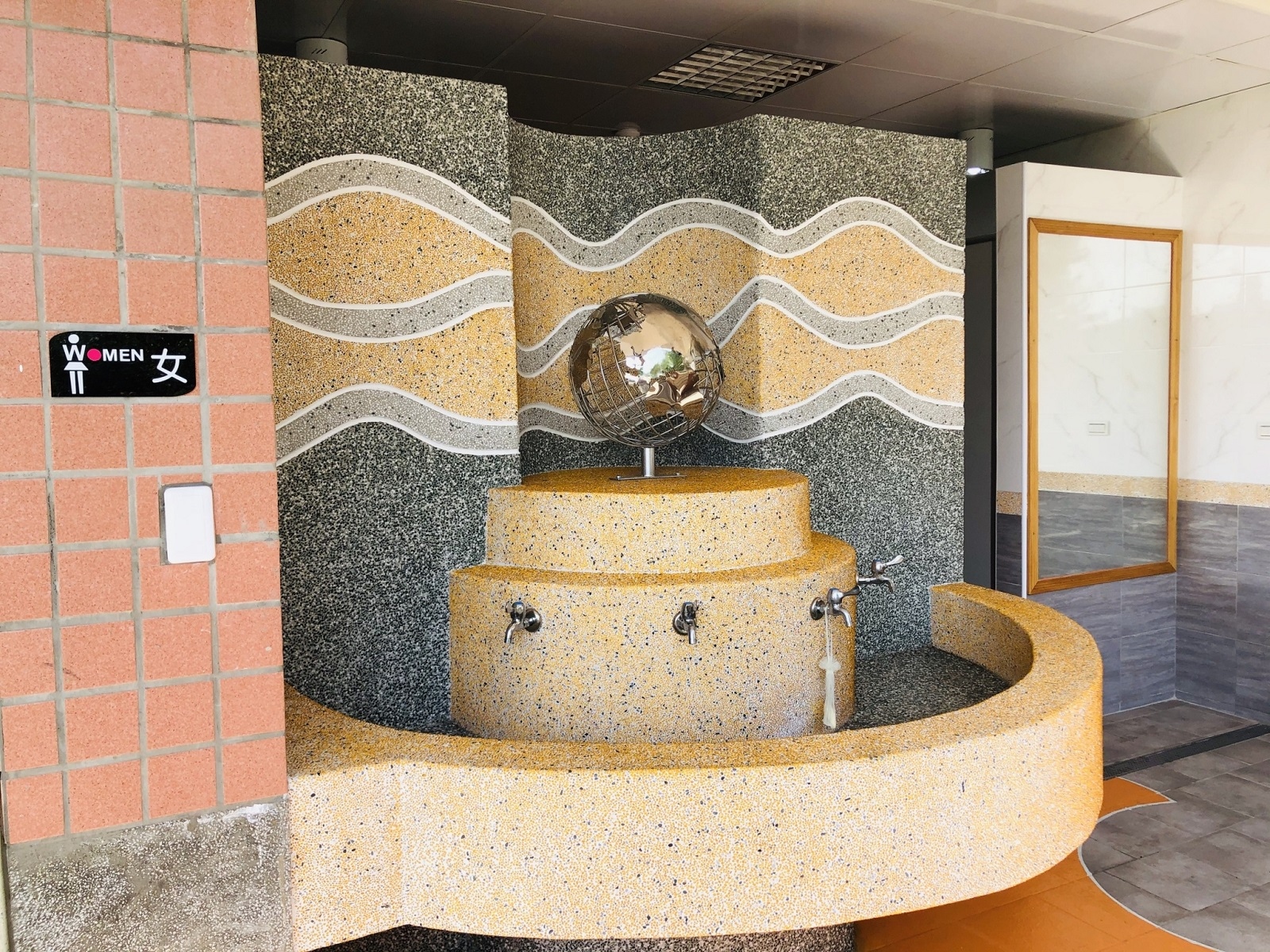 廁所外觀設置地球儀裝置藝術，並在牆上鑲嵌波浪紋琉璃石增添特色。圖／台中市教育局提供