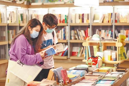 台灣出版新書總量，去年創18年新低。圖為兩位戴著口罩的年輕人在書店內選書。（本報資料照片）